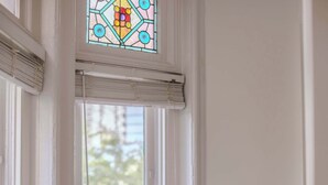 Ein Zimmer mit Fenster, Tisch, Stuhl und Buch.