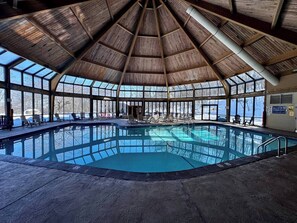 An indoor swimming pool with a wooden ceiling and large windows. - Luxury Poconos Townhouse with Resort Perks! (Tannersville)
