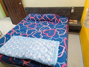 A bed with a patterned bedspread and a floral pillow. - Patel's Home - Near Vadodara Airport /Amit Nagar (Vadodara)