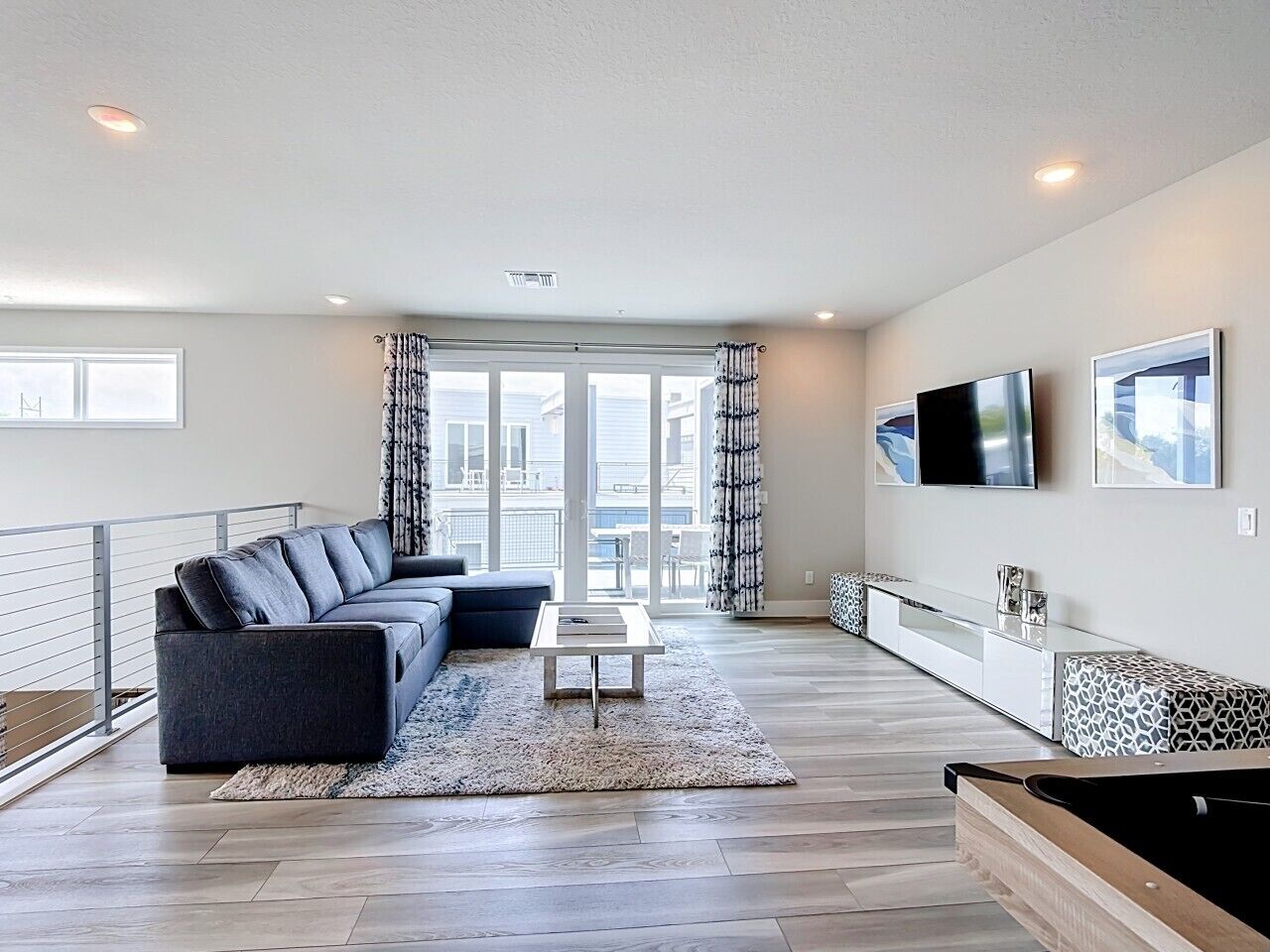 A modern living room with a sofa, coffee table, and a TV mounted on the wall.