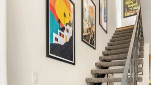 Una escalera con barandilla alfombrada y peldaños, que conduce a un piso superior.
