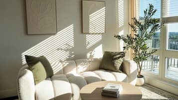 Ein modernes Wohnzimmer mit einer Eckcouch, einem runden Couchtisch und einem Blumentopf.