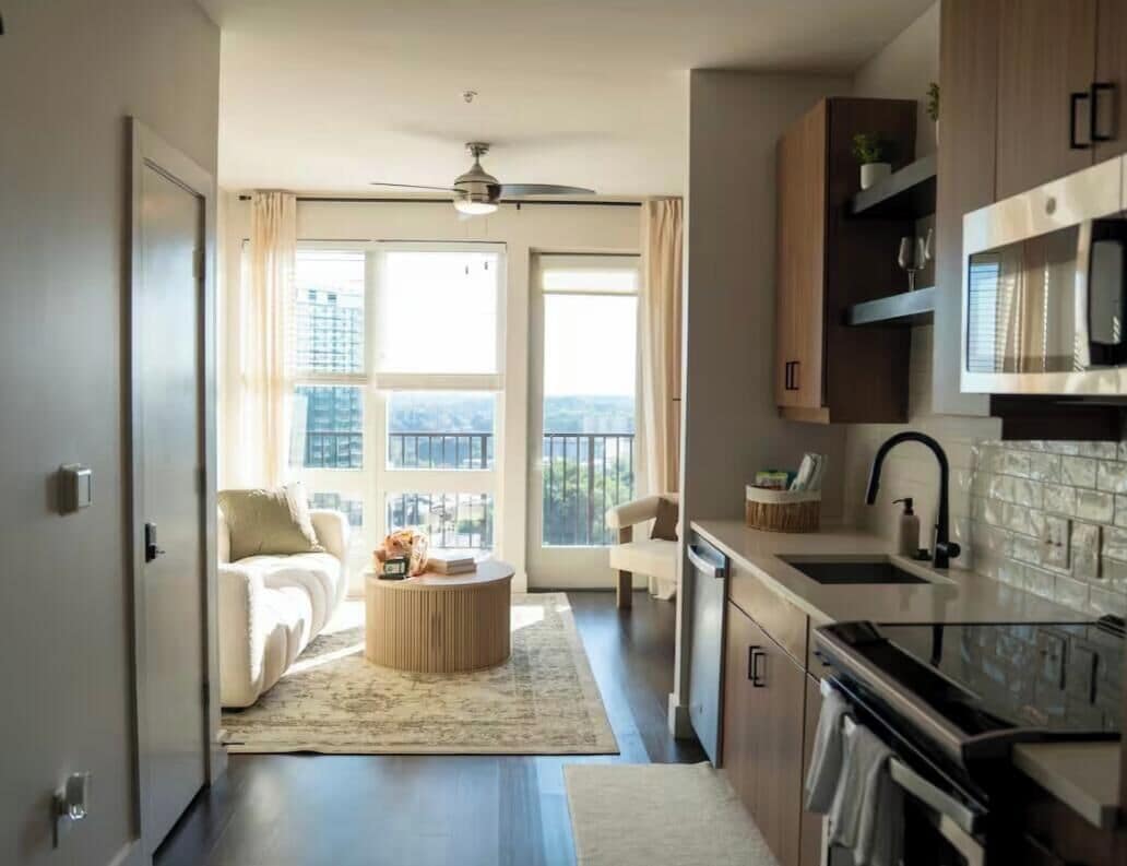 A modern apartment with a living area, kitchen, and balcony.