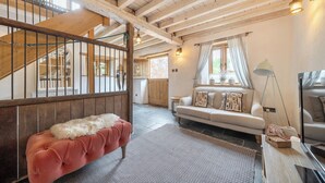 Ein gemütliches Wohnzimmer mit einer Couch, einer Bank und einer Treppe.