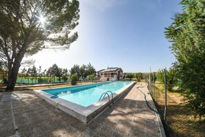 A swimming pool with a house in the background.