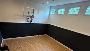 Ein Basketballplatz mit Korb, Holzboden und einer Bank.