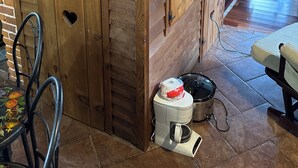 A wooden structure with heart-shaped cutouts, a staircase, and a coffee maker on the floor.