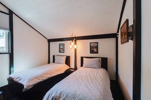A room with two single beds, a wall-mounted light fixture, and two framed pictures. - Cozy Sunriver Retreat - SHARC Passes, Bike and BBQ (Sunriver)