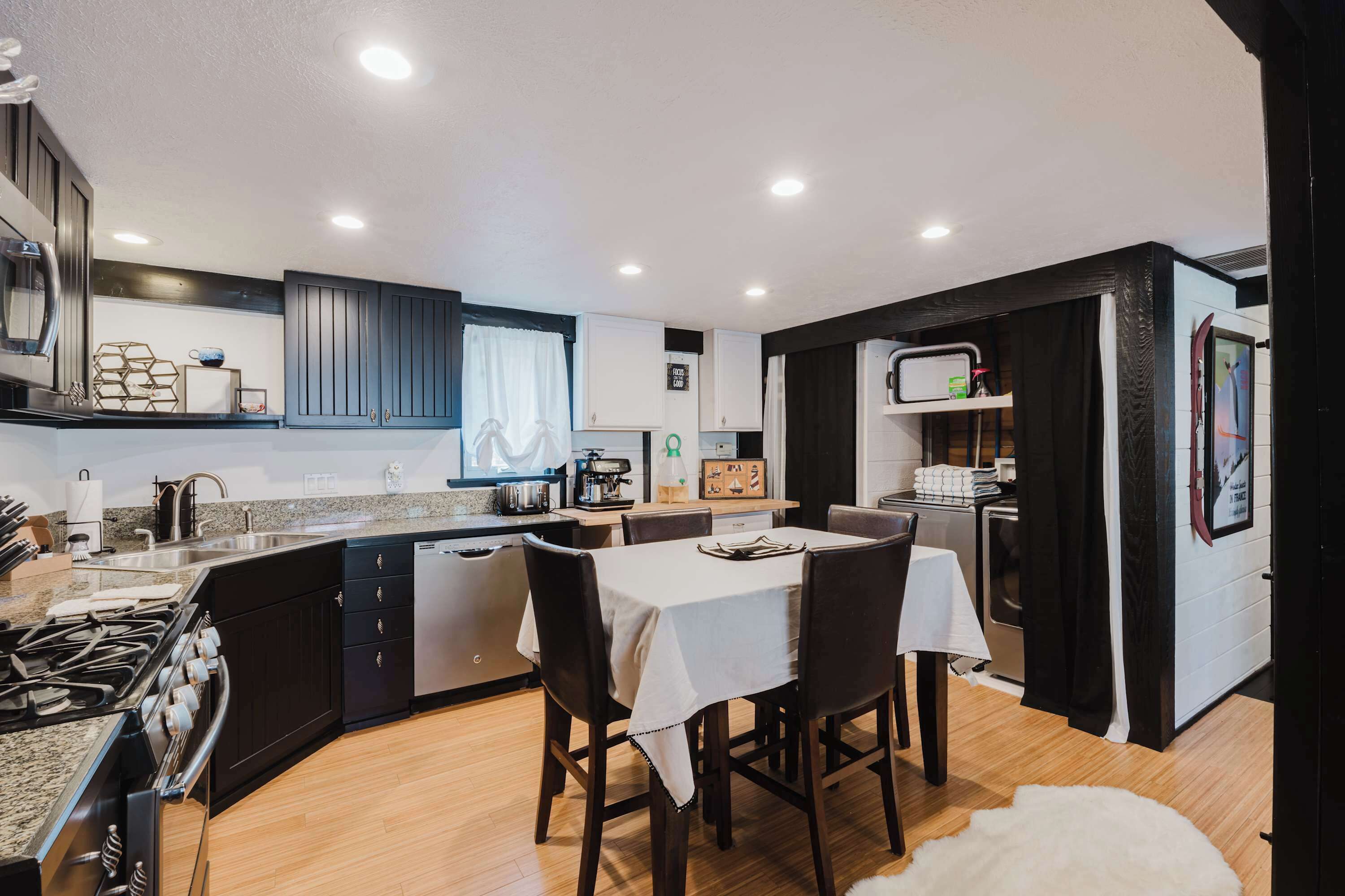 Cocina compacta con comedor, equipada con estufa, lavaplatos y refrigerador.