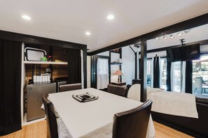 A modern dining area with a table, chairs, and a kitchen area with appliances. - Cozy Sunriver Retreat - SHARC Passes, Bike and BBQ (Sunriver)