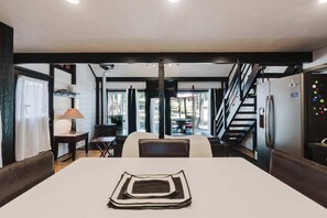 A modern interior with a dining area, a fireplace, and a view of the outdoors. - Cozy Sunriver Retreat - SHARC Passes, Bike and BBQ (Sunriver)