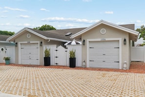 A two-car garage with a number 2308 on the left and 2306 on the right, both with white doors and black handles.