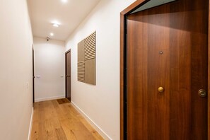 A hallway with wooden flooring, a wooden door, and a wall-mounted panel. - Charming, tastefully furnished apartment of 50 sqm, able to accommodate up to 4 guests, located on the first floor of a building with a lift (accessible via a few steps). The property is situated in a quiet district offering all amenities and excellent c (Palermo)