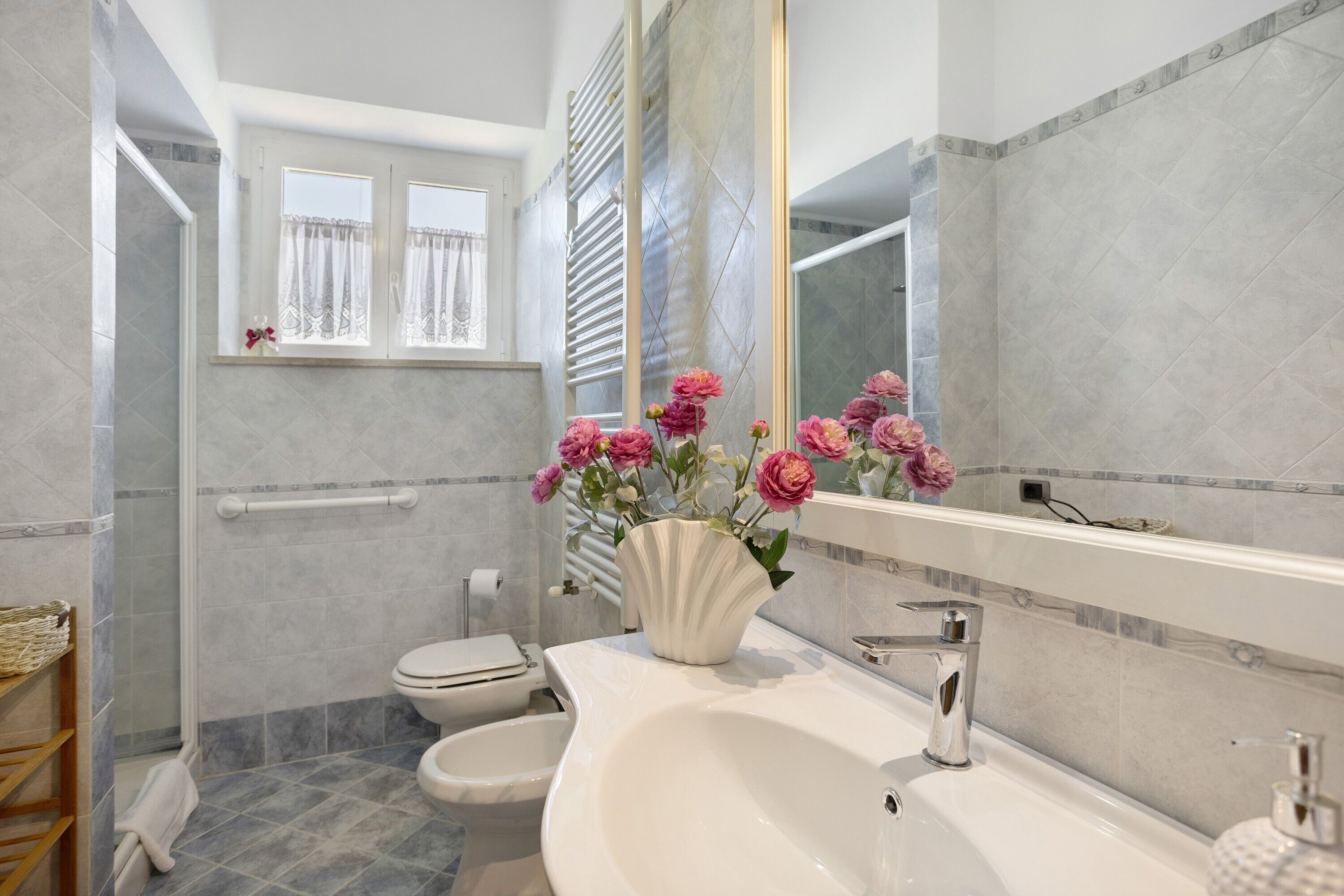 A bathroom with a white sink, a toilet, and a shower area.