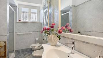 A bathroom with a white sink, a toilet, and a shower area.