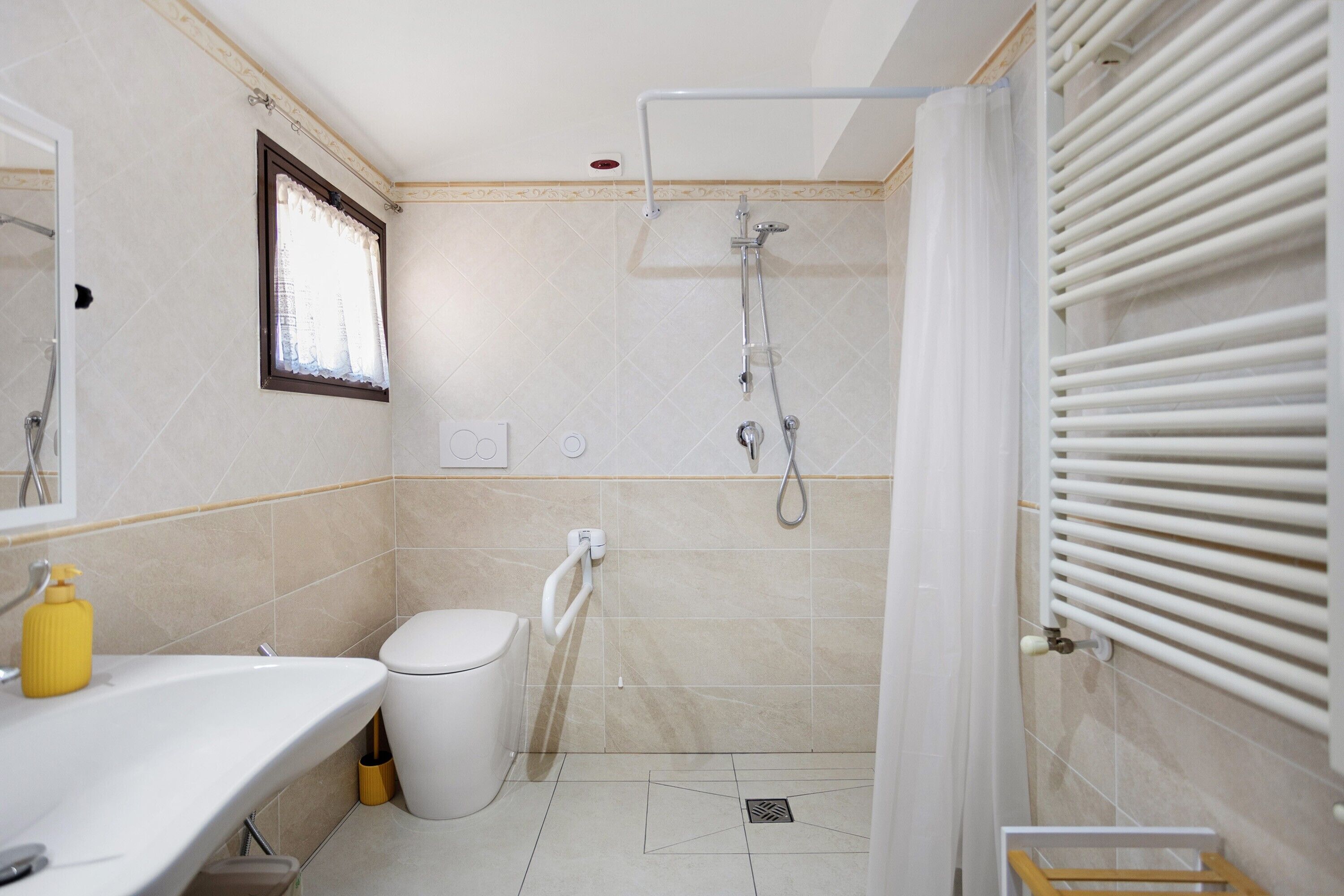 Ein Badezimmer mit Toilette, Waschbecken, Dusche und Handtuchhalter.