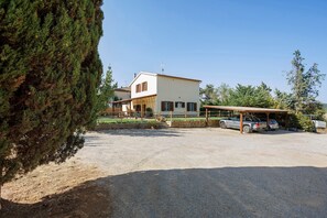 A two-story house with a covered carport and a gravel driveway. - Holiday Home 'Appartamento 3' with Shared Garden, Wi-Fi and Air Conditioning (Montiano)