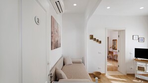 Un dormitorio con cama, televisor y escritorio.