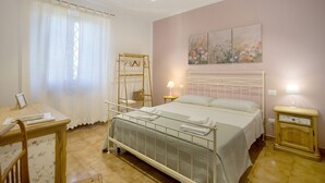 Una camera da letto con un letto, comodini, un armadio e una finestra con tende.