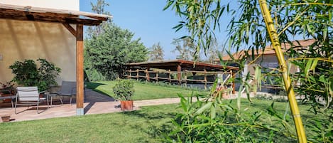 A patio area with outdoor furniture, a pergola, and a well-maintained lawn.