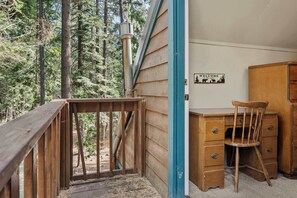 A wooden deck with a metal railing, a wooden desk with drawers, a chair, and a welcome sign with a cabin silhouette. - Tahoe Park Family Retreat (Tahoe City)