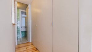 A narrow hallway with a wooden floor leading to a bathroom with a green tiled wall. - Downtown 2BR in Santa Justa by LovelyStay (Lisboa)