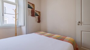A room with a bed, a window, and a door. - Downtown 2BR in Santa Justa by LovelyStay (Lisboa)