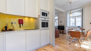 A modern kitchen with white cabinets, a yellow backsplash, and a Bosch oven. - Downtown 2BR in Santa Justa by LovelyStay (Lisboa)