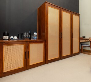 A wooden cabinet with woven doors, a coffee maker, glasses, and bottles on top. - Andriyala (Haputale)