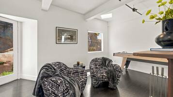 Una sala moderna con dos sillones estampados, una mesa de centro y una mesa de billar.