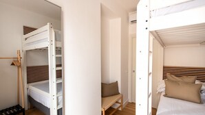 A room with bunk beds, a chair, and a bed with pillows. - GuestHost - Casa Tramonto Elegant Flat (Palermo)