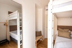 A room with bunk beds, a chair, and a bed with pillows. - GuestHost - Casa Tramonto Elegant Flat (Palermo)