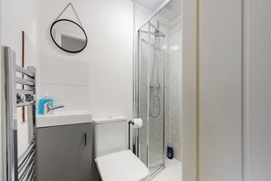 A modern bathroom with a toilet, sink, and shower. - 4 bed, 4 en-suite house (Warrington)