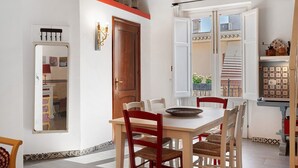 Un comedor con mesa de madera, sillas rojas y ventana con vistas al exterior.