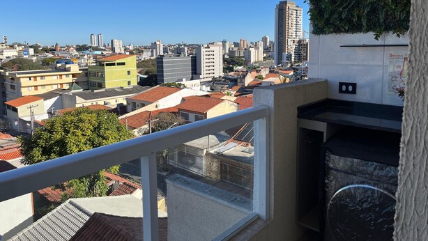 Un balcón con vista a un paisaje urbano, con edificios de diferentes alturas y colores.