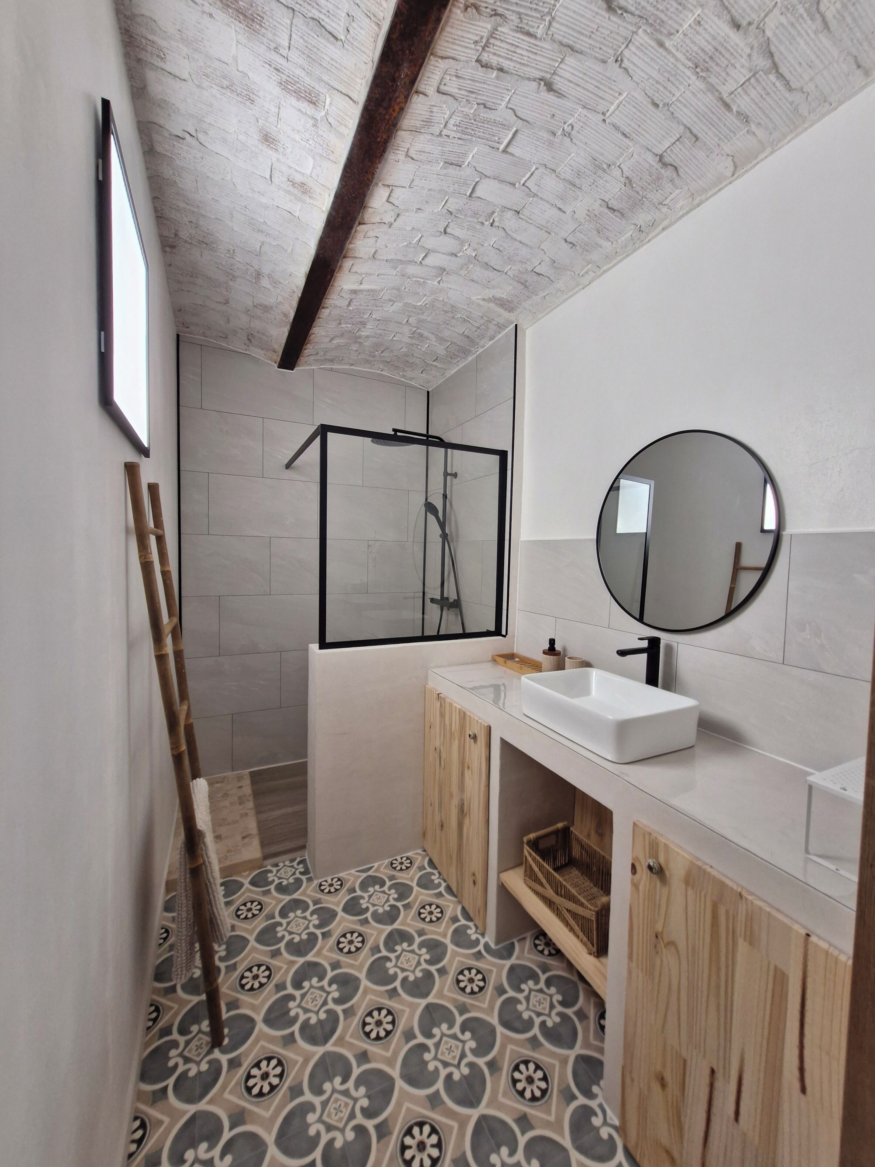 A bathroom with a shower, a sink, and a mirror.