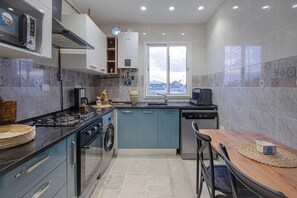Eine moderne Küche mit Gasherd, Backofen, Geschirrspüler und einem Fenster mit Ausblick.