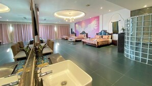 Eine Hotelhalle mit Rezeption, Sitzgelegenheiten und einem großen Spiegel.