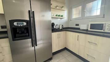A kitchen with a stainless steel refrigerator, a microwave, and a water dispenser.