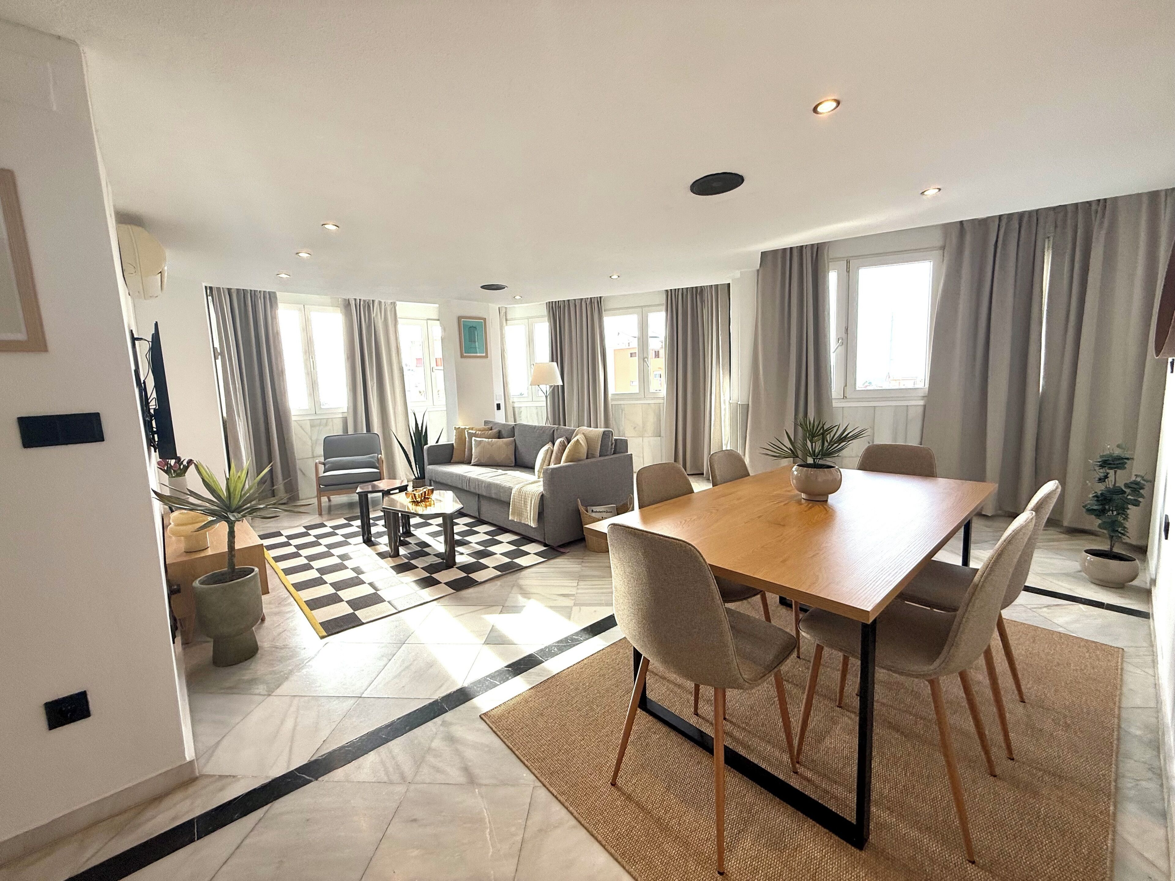 A modern living room with a sofa, coffee table, and dining table.