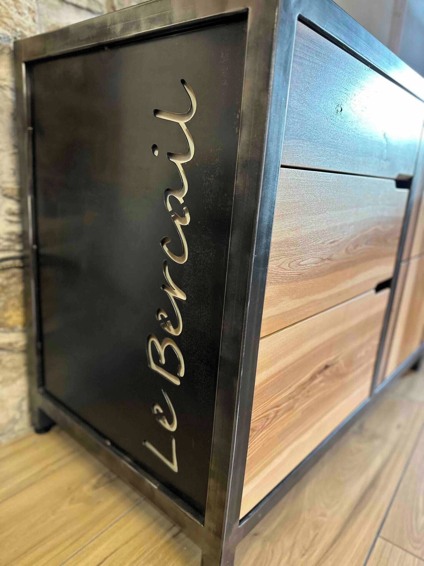 A wooden cabinet with drawers and a metallic front panel with the inscription 'LeBercair'.