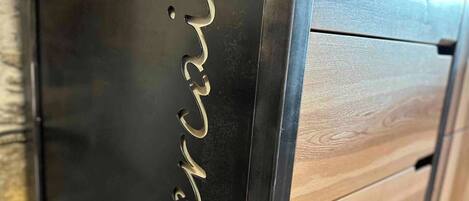 A wooden cabinet with drawers and a metallic front panel with the inscription 'LeBercair'.