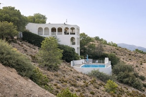 A white building with arched windows and a swimming pool on a hillside. - Mediterranean Family Home with Private Pool & Panoramic Views (Alguazas)