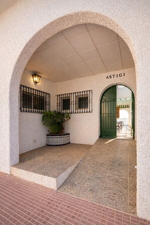 An arched entrance with a tiled floor, a potted plant, and a sign that reads 'ASTIGI'. - Mediterranean Family Home with Private Pool & Panoramic Views (Alguazas)