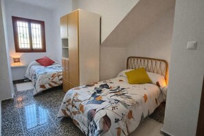 A bedroom with two beds, a wardrobe, a window, and a sloped ceiling. - Mediterranean Family Home with Private Pool & Panoramic Views (Alguazas)