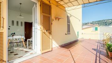 Ein Wohnhaus mit Terrasse, Essbereich und Blick auf die umliegende Landschaft.