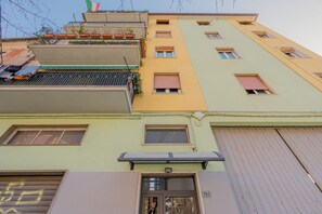 Un immeuble à plusieurs étages, doté de balcons, de fenêtres et d’un numéro de porte bien visible.