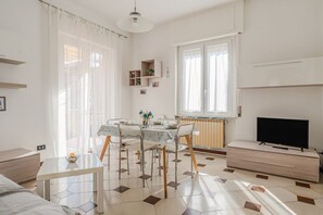 A modern, well-lit room with a dining table, chairs, a TV, and a radiator. - Cosy 95 sqm flat for 5 people, on the 1st floor of a building WITHOUT lift (there are stairs for access).The apartment is located in the Rebocco district of La Spezia, a quiet area well served by public transport. The city centre can be reached in about  (La Spezia)