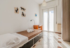 A single bed with a white and brown bedspread, a desk with a chair, a lamp, and a window with a view. - Cosy 95 sqm flat for 5 people, on the 1st floor of a building WITHOUT lift (there are stairs for access).The apartment is located in the Rebocco district of La Spezia, a quiet area well served by public transport. The city centre can be reached in about  (La Spezia)