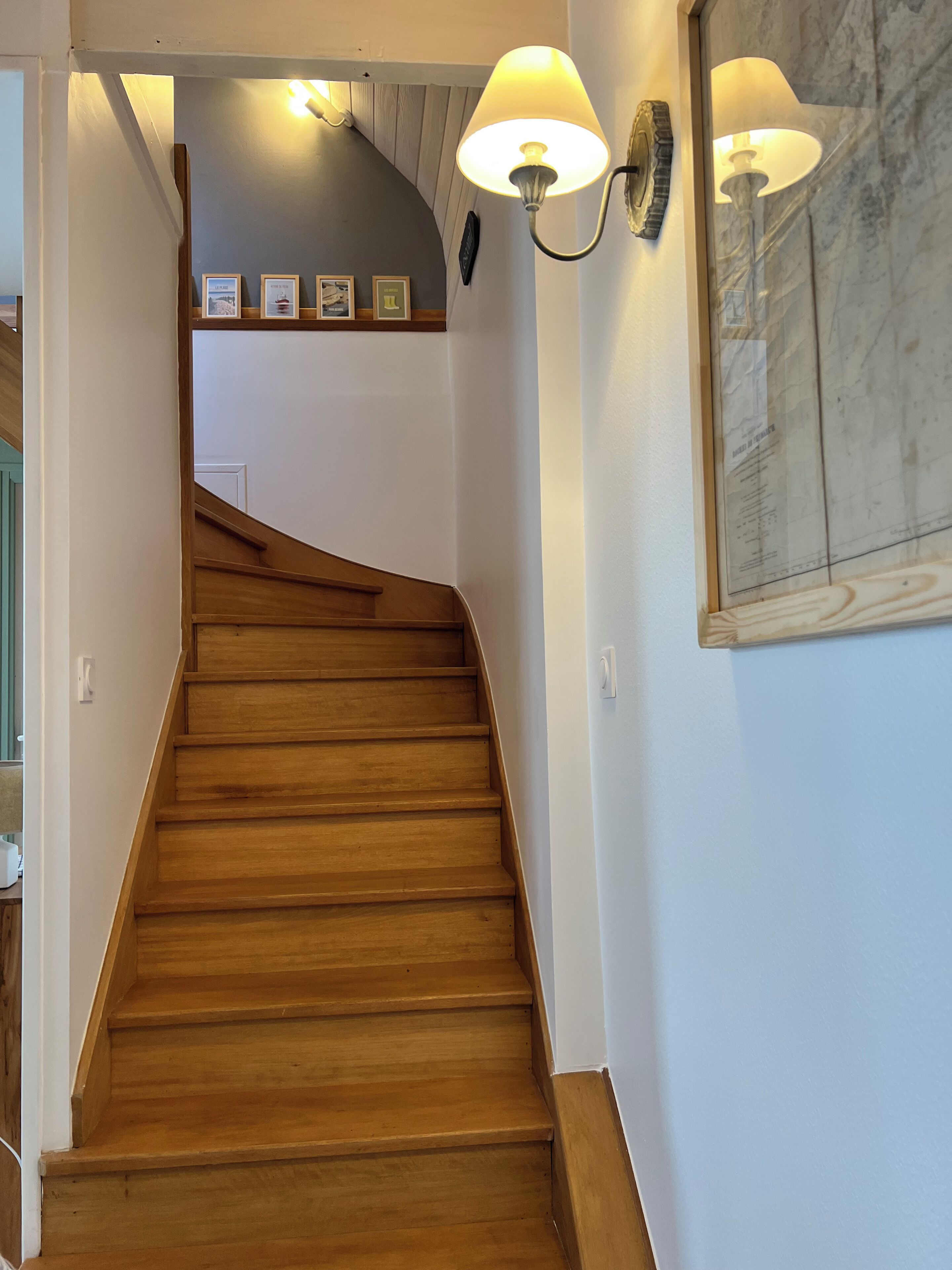 A wooden staircase with a curved design leading to a landing area.